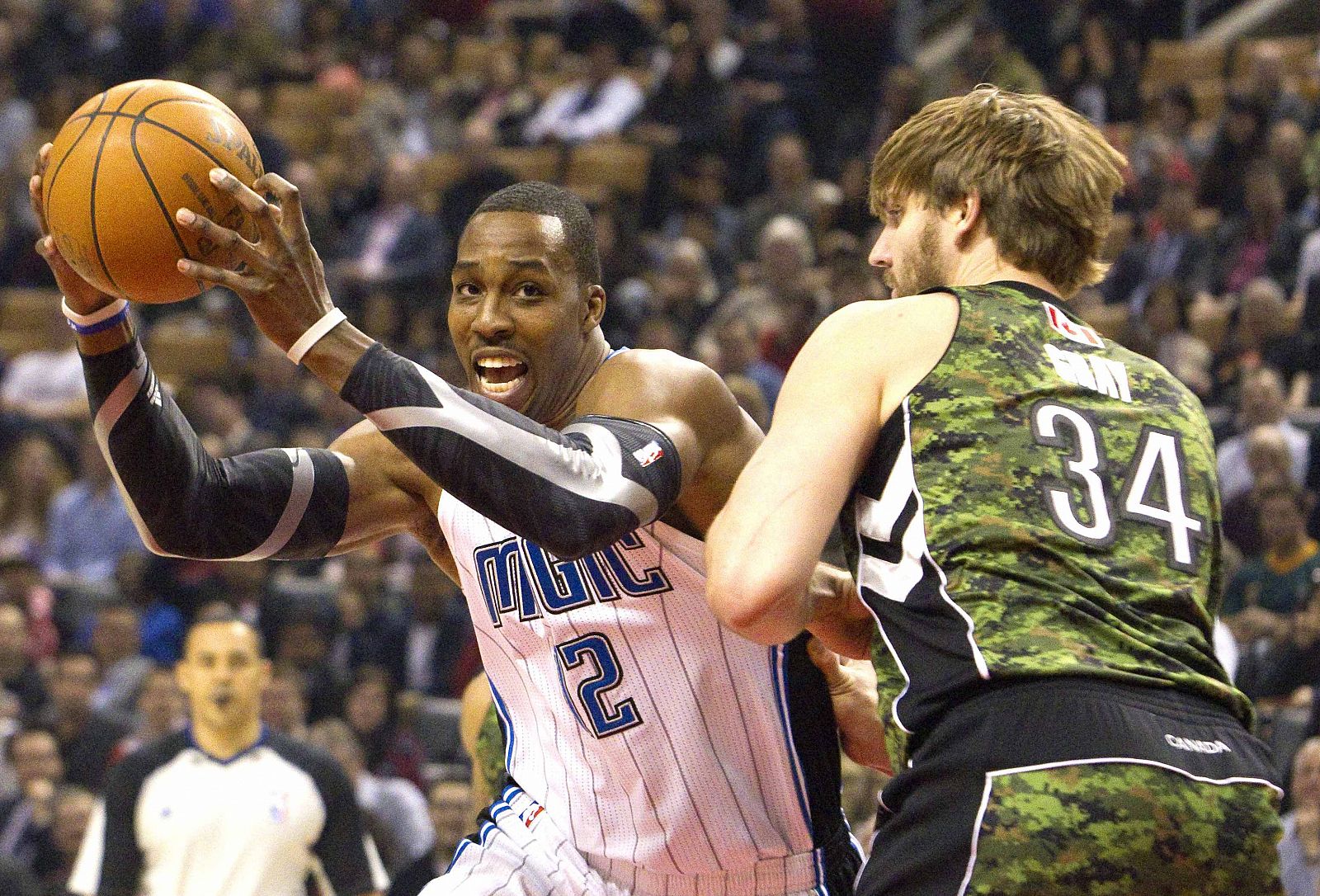 El jugador de los Raptors, Aaron Gray y Dwight Howard de los Magic durante el partido que ha enfrentado a amabos equipos.