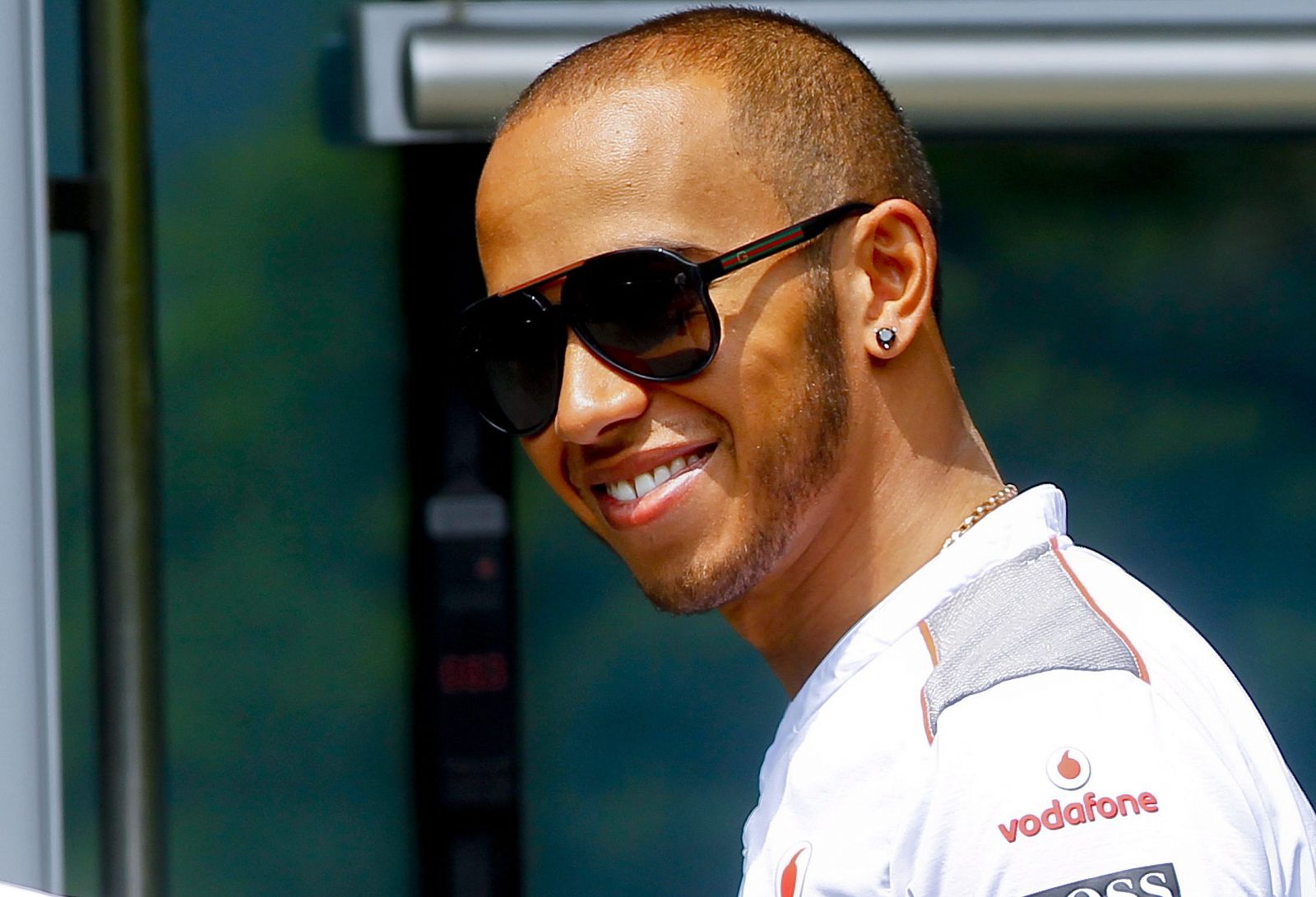 El piloto británico Lewis Hamilton sonríe en el paddock.