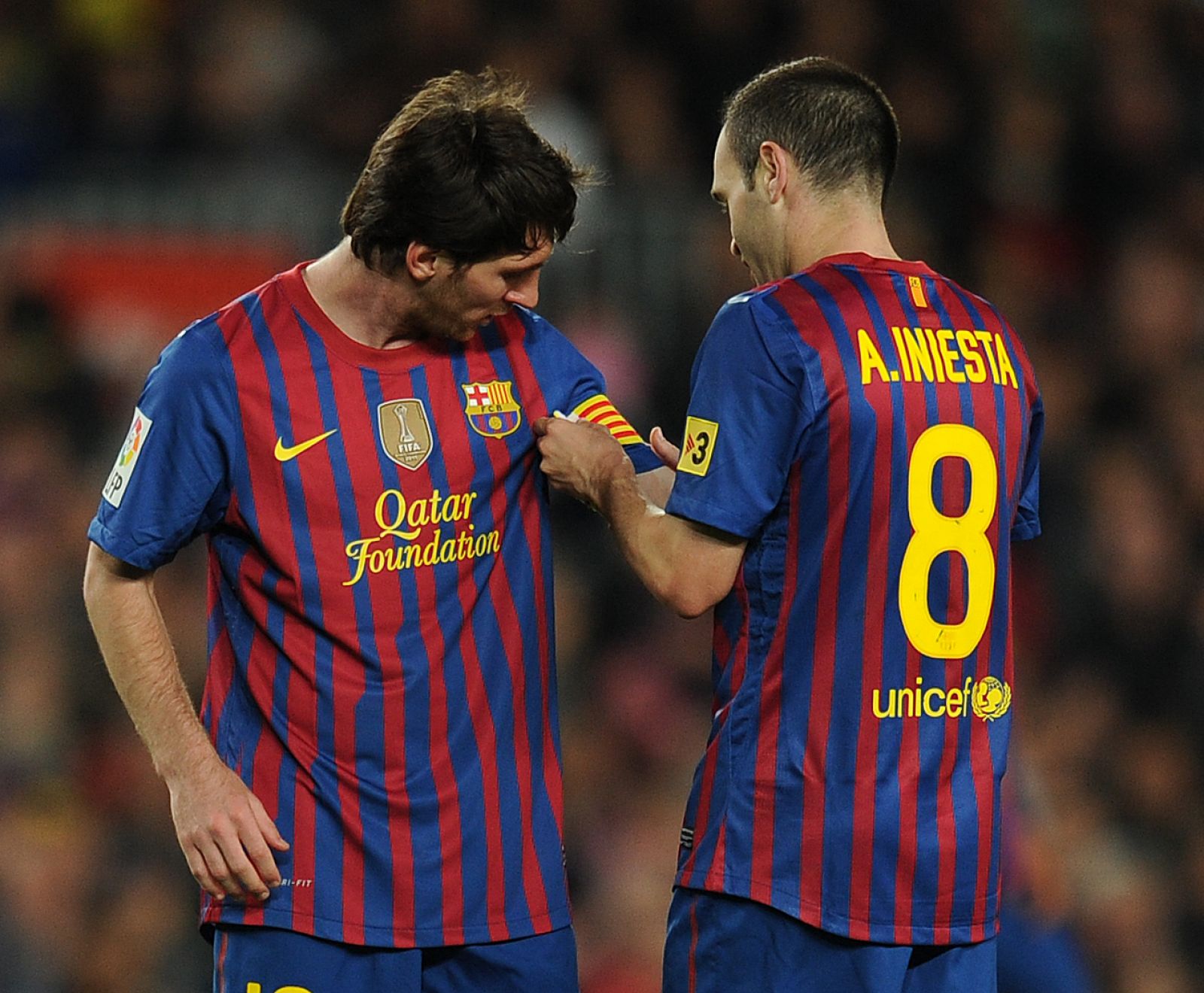 Andrés Iniesta da a Leo Messi el brazalete de capitán del Barça al ser sustituido en el partido ante el Málaga.