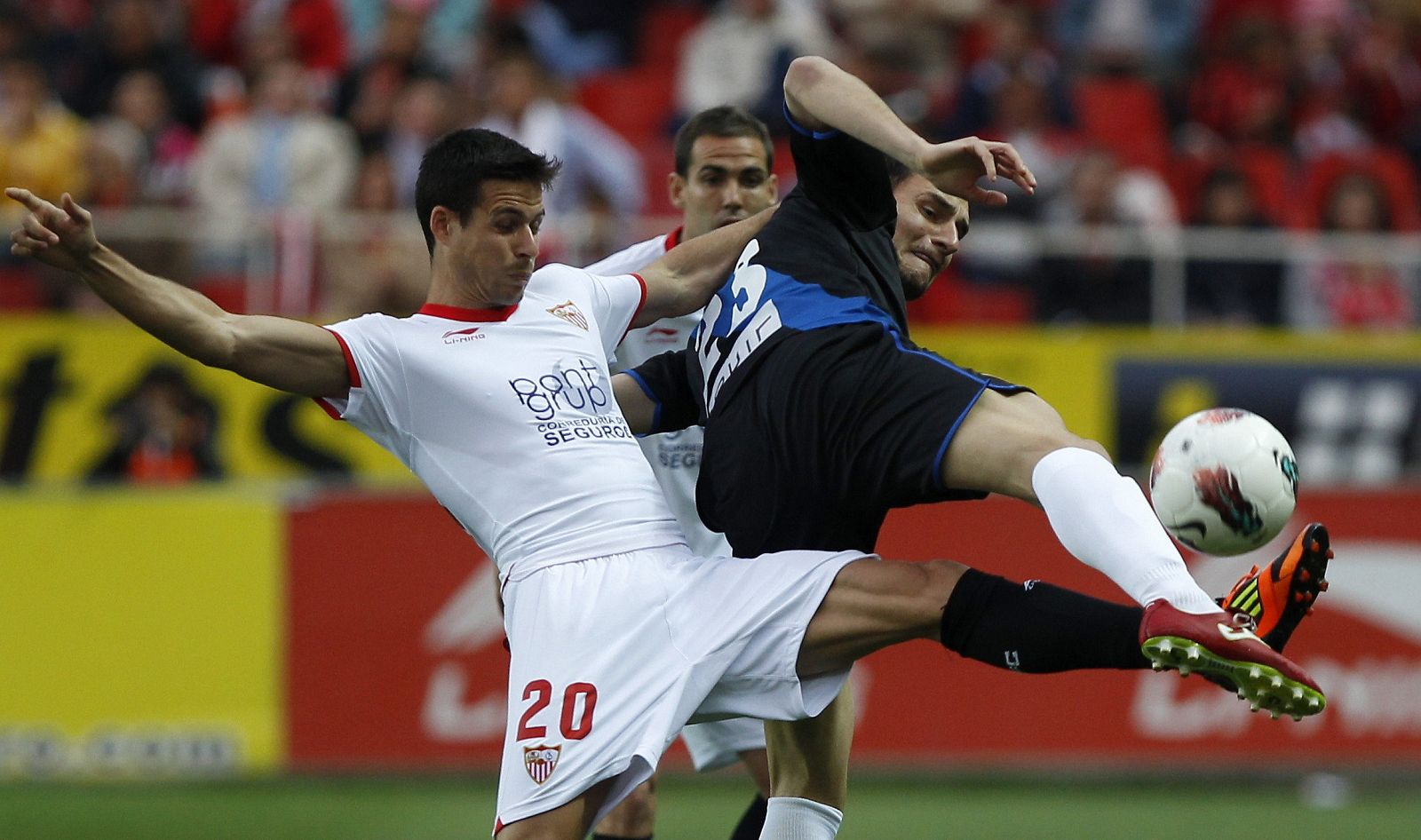 El delantero del Sevilla Manu del Moral (i) pelea un balón con el del Rayo Vallecano Andrija Delibasic.