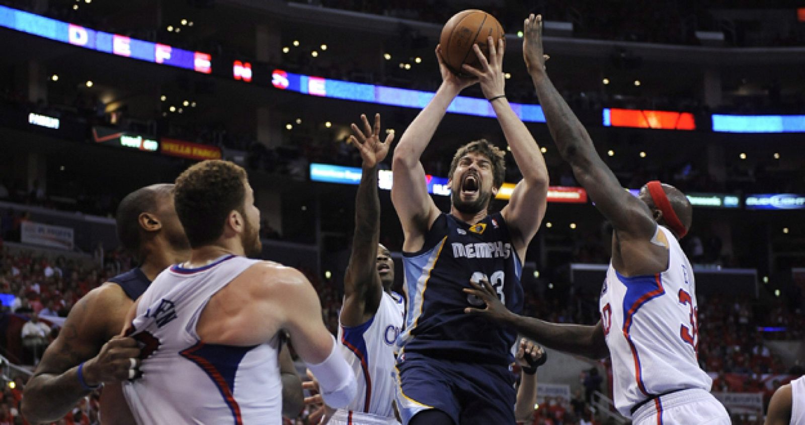 El jugador de Grizzlies Marc Gasol se dirige a canasta ante la marca de Blake Griffin y Reggie Evans, de los Clippers.