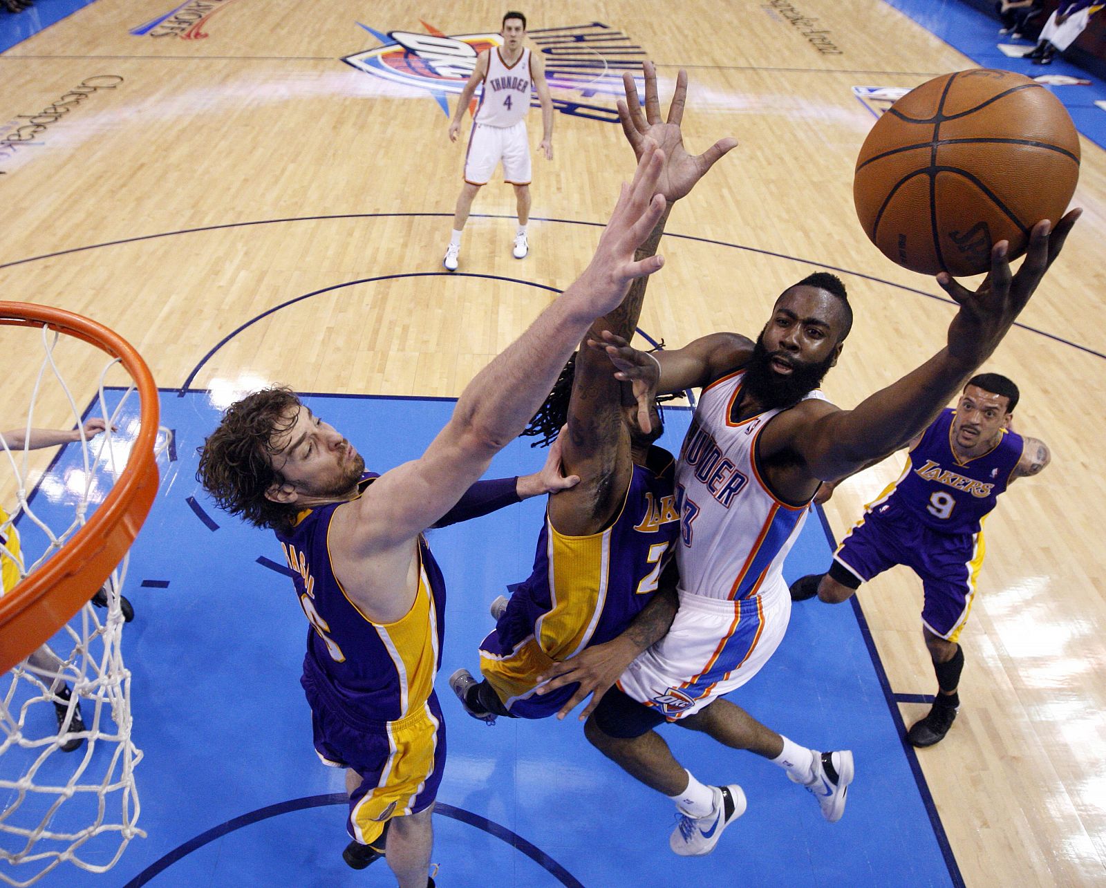 El jugador de Thunder James Harden (d) intentar encestar ante la marca de Pau Gasol (i) y Jordan Hill (c) de Lakers.
