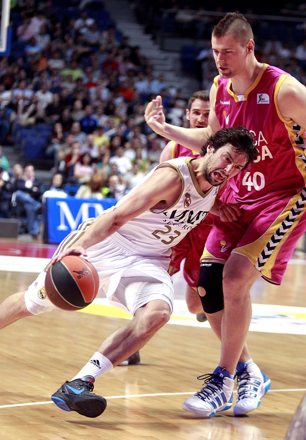 El base del Real Madrid, Sergio Llull (i), penetra a canasta.