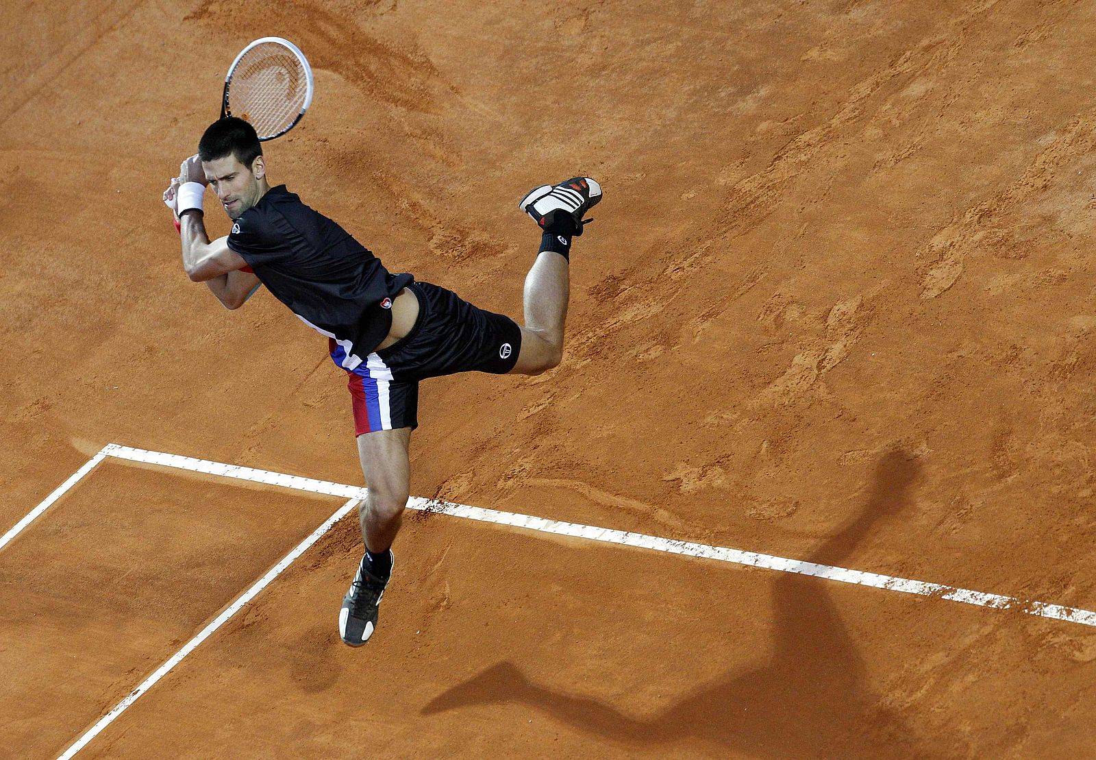 El serbio Novak Djokovic devuelve una pelota al suizo Roger Federer