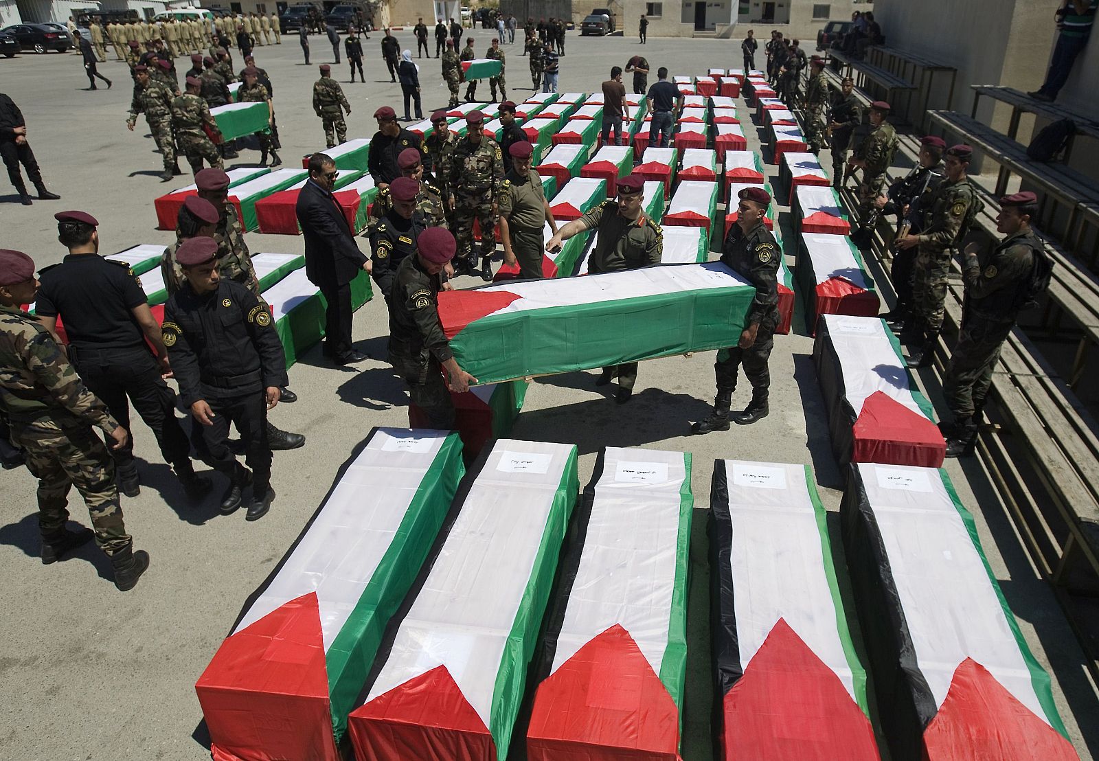 Las fuerza de seguridad palestinas recogen los féretros de 91 cuerpos de palestinos entragados por Israel