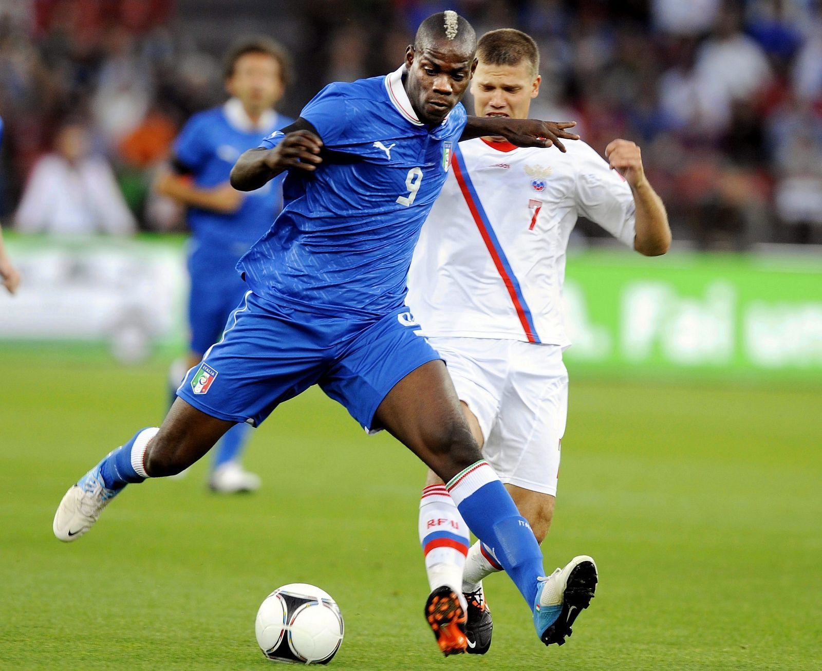 El internacional italiano Mario Balotelli lucha por el balón con el ruso Igor Denisov.