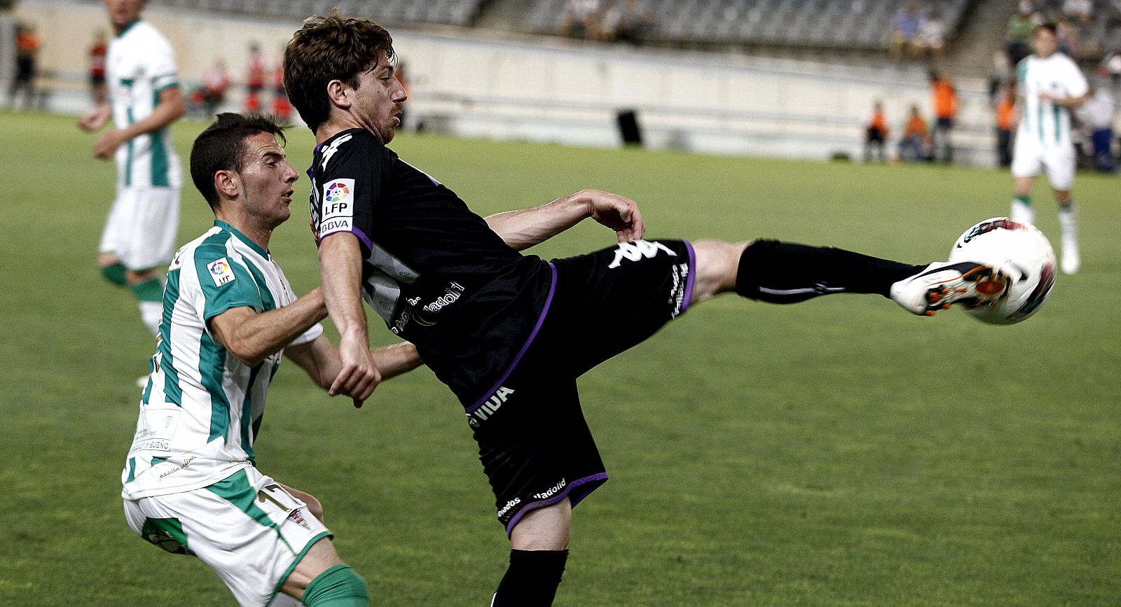 El jugador del Valladolid, Javier Baraja (d), golpea el balón ante el defensa del Córdoba, José Manuel Fernández
