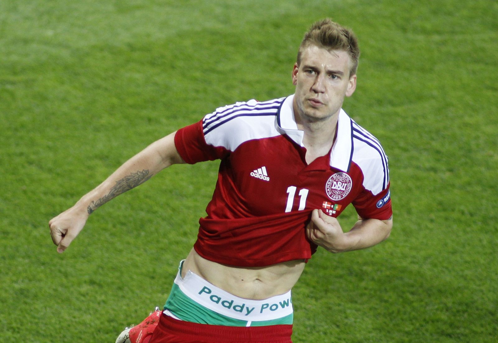 El delantero danés Nicklas Bendtner mostrando la publicidad en pleno partido.