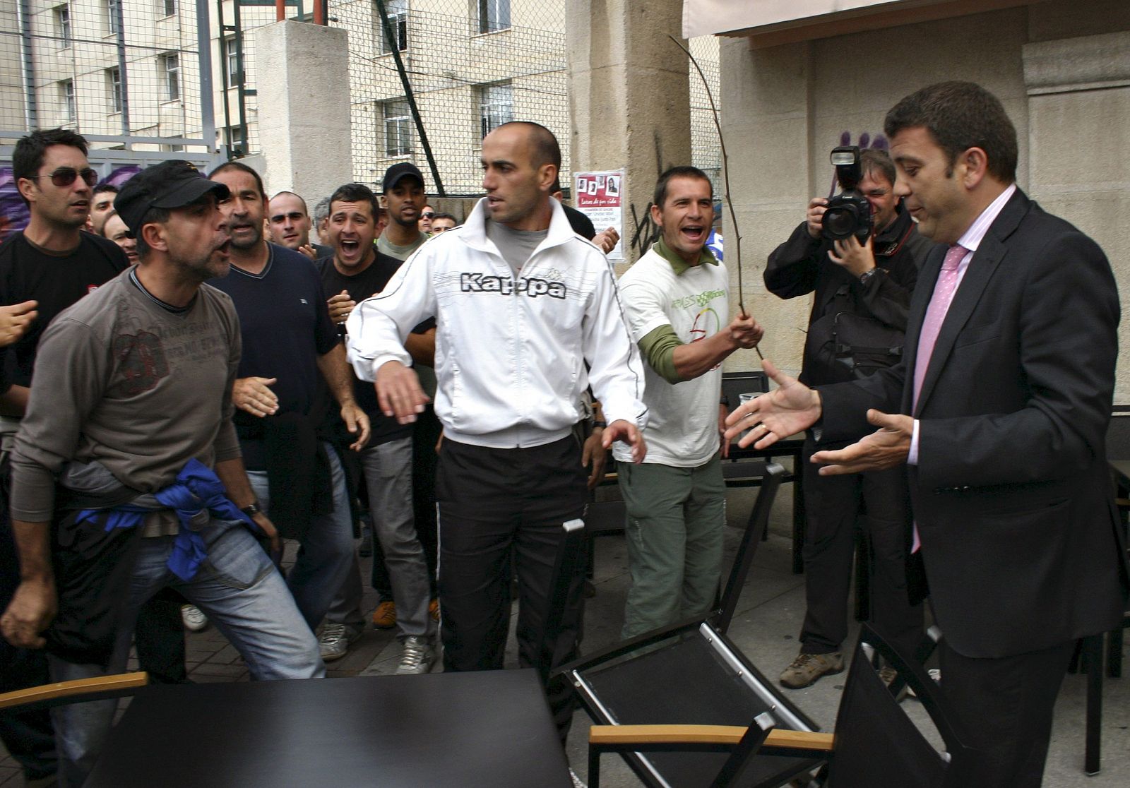 El alcalde de Ponferrada, Carlos López Riesco (derecha), ante el piquete de mineros en la terraza de una cafetería.