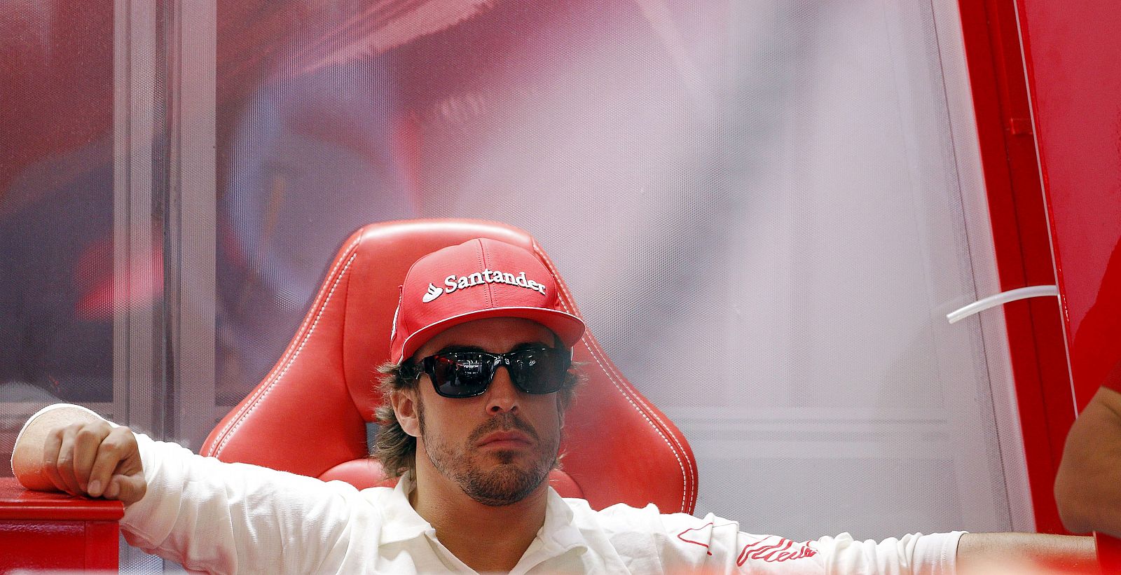 El piloto español Fernando Alonso (Ferrari) descansa tras finalizar la tercera y última sesión de entrenamientos libres