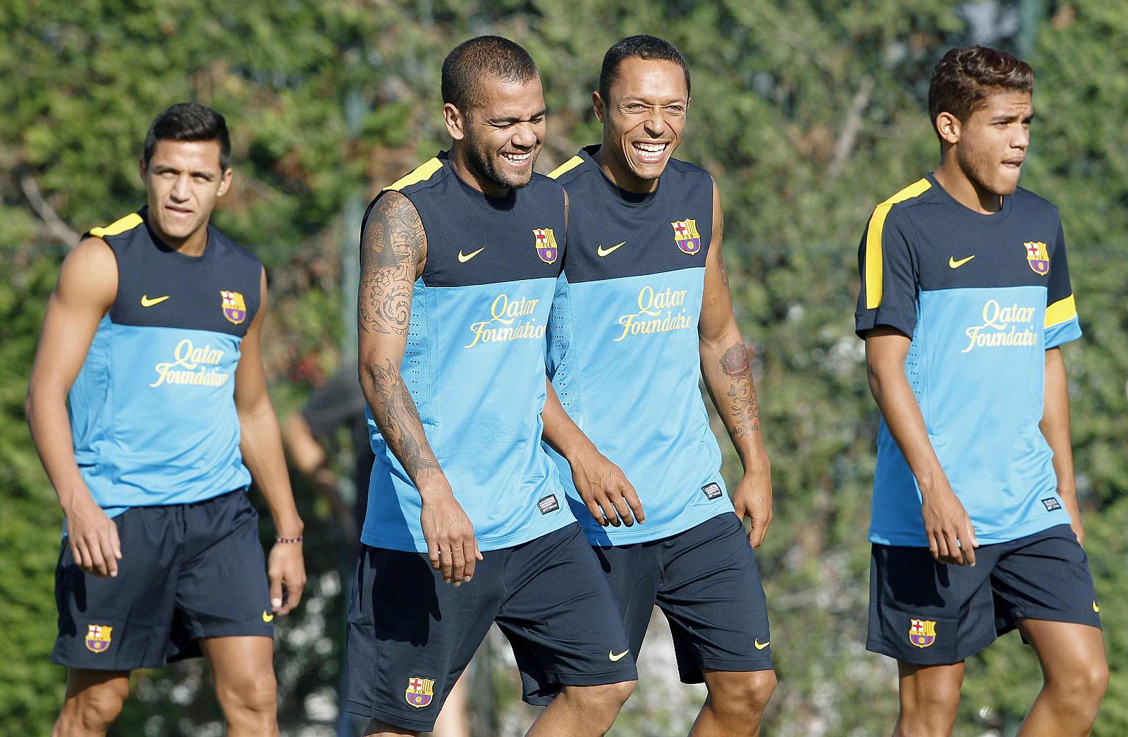 Los jugadores del FC Barcelona, Alexis Sánchez y los brasileños Dani Alves, Adriano Correia y Rafinha,durante una sesión de entrenamiento en la ciudad deportiva del club.