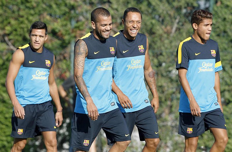 Los jugadores del FC Barcelona, Alexis Sánchez y los brasileños Dani Alves, Adriano Correia y Rafinha,durante una sesión de entrenamiento en la ciudad deportiva del club.