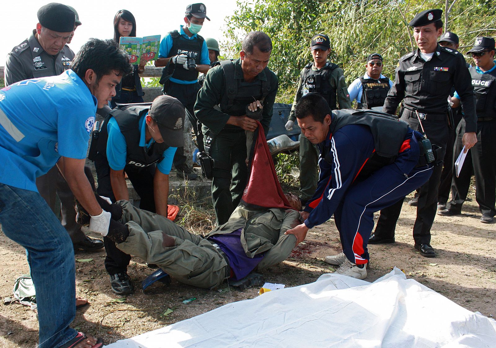 Personal de emergencias traslada el cuerpo de uno de los policías muerto en el sur de Tailandiaa