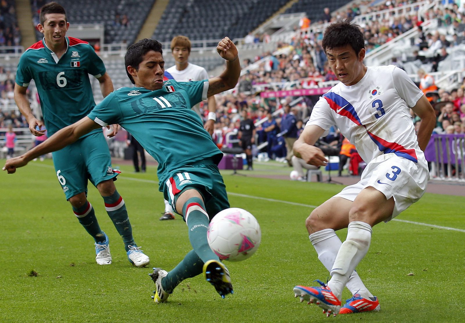 El jugador de Mexico Javier Aquino y el coreano Sukyong Yun, disputan el balón.