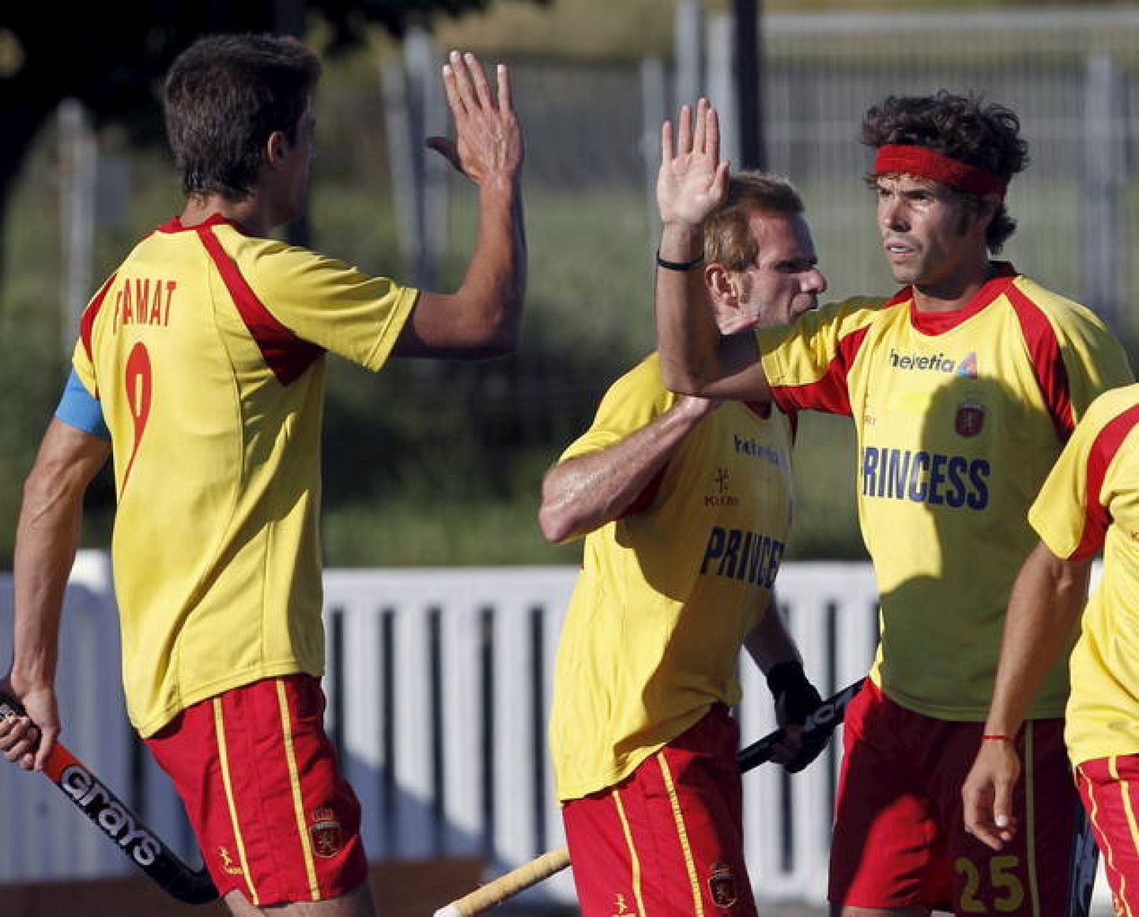 Los jugadores de la selección española de hockey hierba Pol Amat (i) y Ramón Alegre (2 i) felicitan a su compañero Pau Quemada tras marcar ante Gran Bretaña en un amistoso.