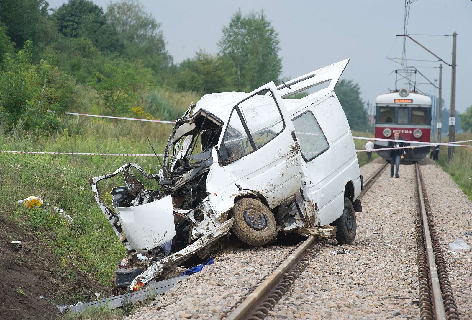 Los restos del minibus siniestrado en Bratoszewice, Polonia, tras colisionar con un tren.