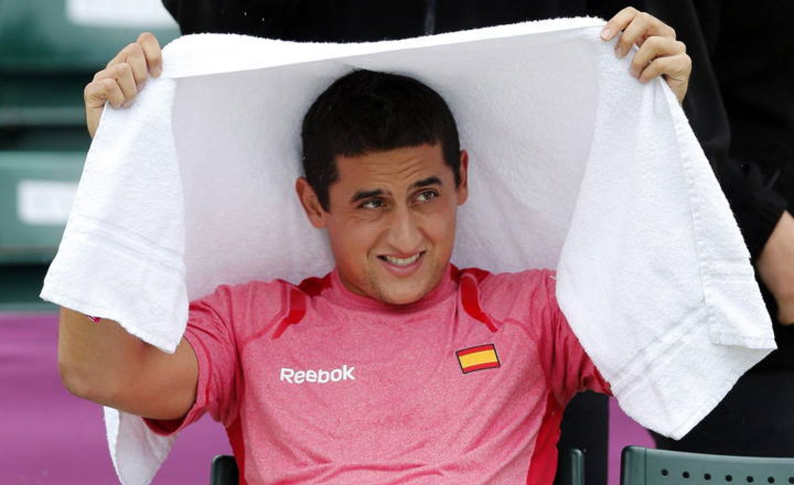 Nicolás Almagro se protege de la lluvia en Londres 2012