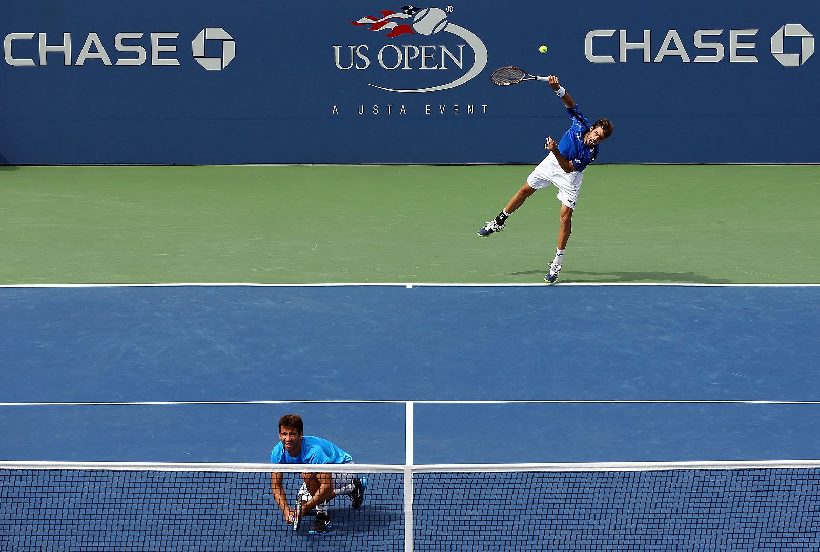 Marcel Granollers realiza un saque con Marc López esperando en la red