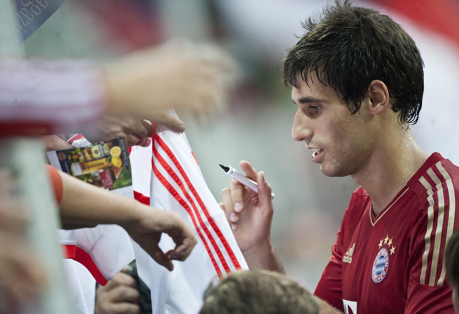 Javi Martínez firma autógrafos después de un partido de la Bundesliga.