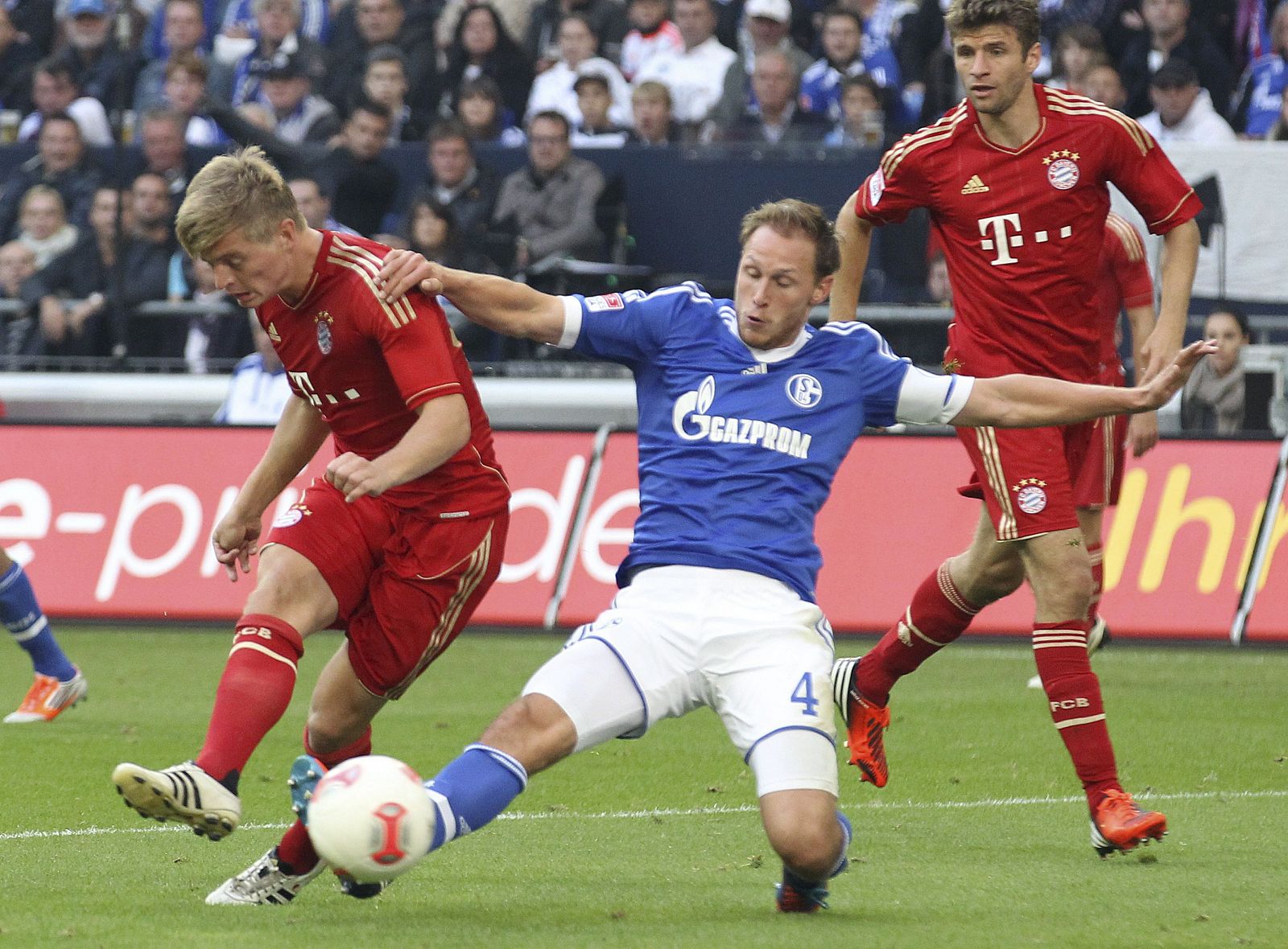 El jugador del Schalke Benedikt Hoewedes lucha por el balón con Toni Kroos del Múnich durante el partido que les enfrentó en el Veltins Arena en Gelsenkirchen.