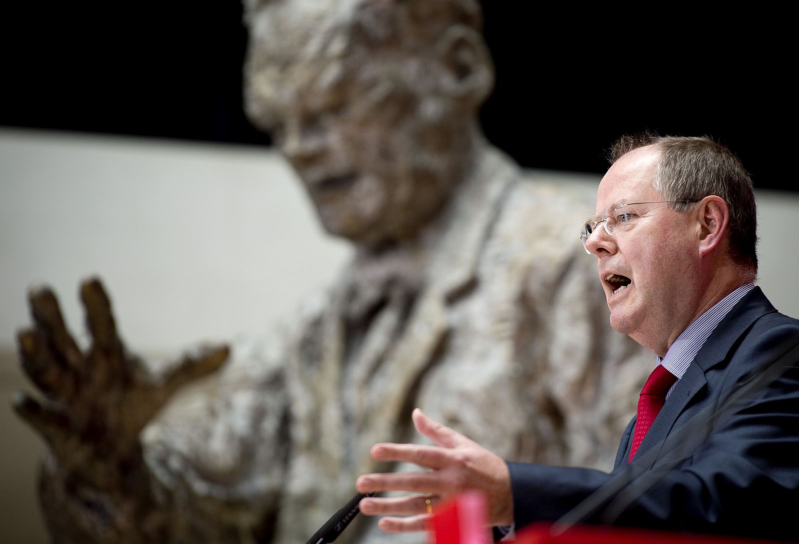 El candidato socialdemócrata, junto a la estatua de Willy Brandt en la sede del partido.