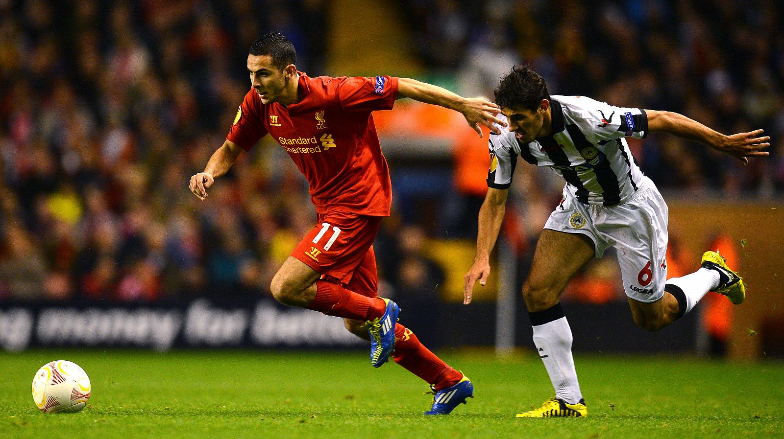 Faraoni (d) y Stewart Downing corren tras el balón en el Liverpool - Udinese