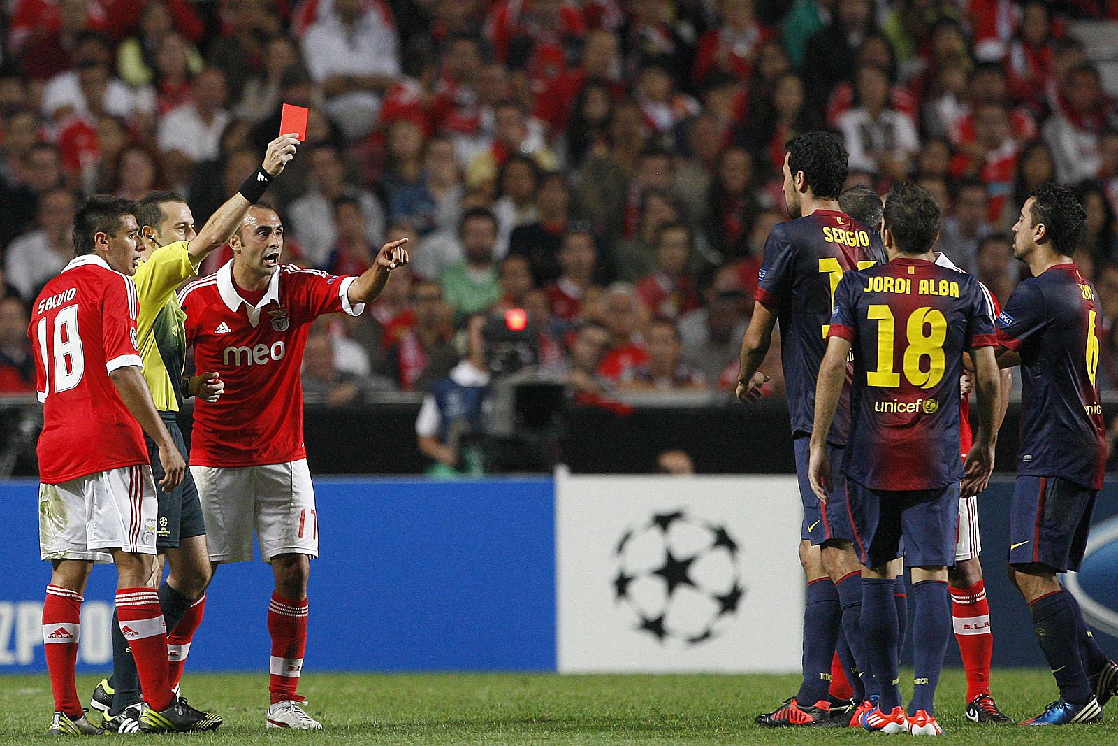 El árbitro Cuneyt Cakir (2i) expulsa al jugador de Barcelona Sergio Busquets (3d) en un partido de la Liga de Campeones contra el Benfica.