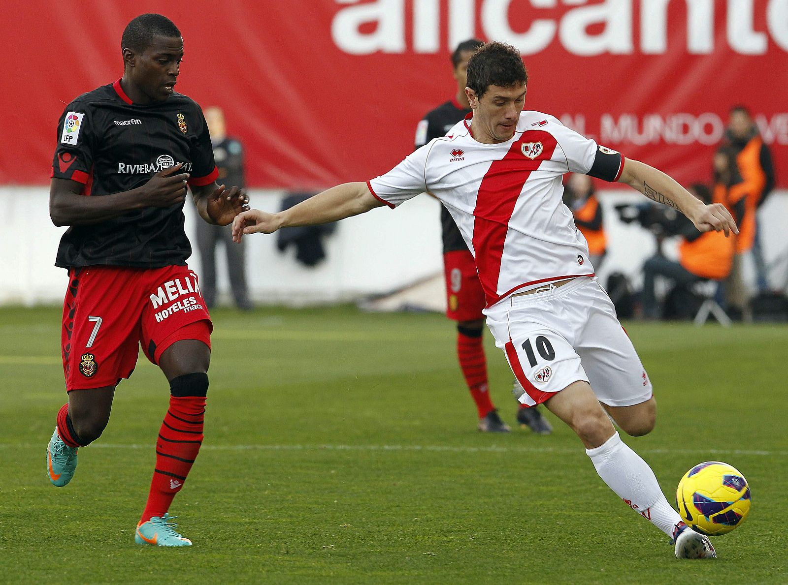 El centrocampista del Rayo Vallecano, Francisco Luna "Piti" (d), golpea la pelota ante la presión del centrocampista francés del Mallorca, Michael Pereira (i)