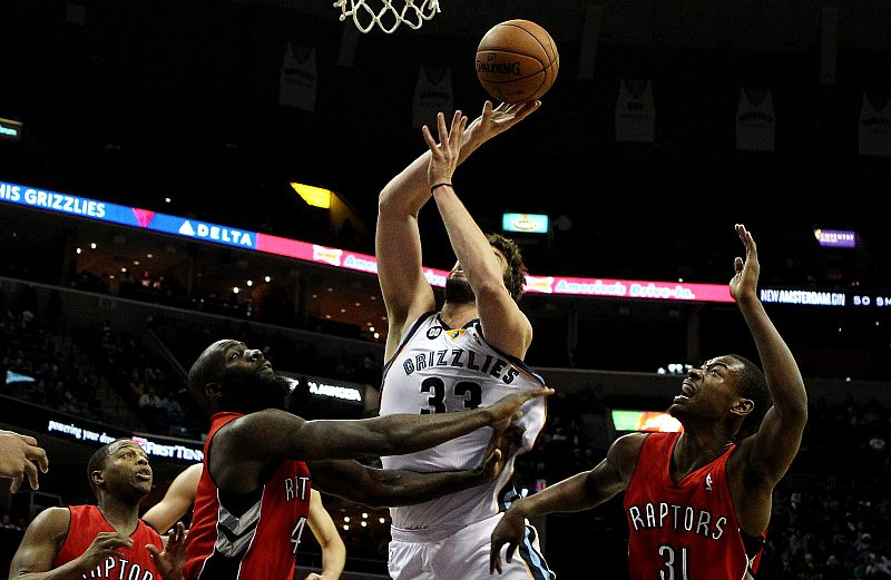 Los jugadores de los Raptors Quincy Acy (i) y Terrence Ross (d) disputan el balón con Marc Gasol.