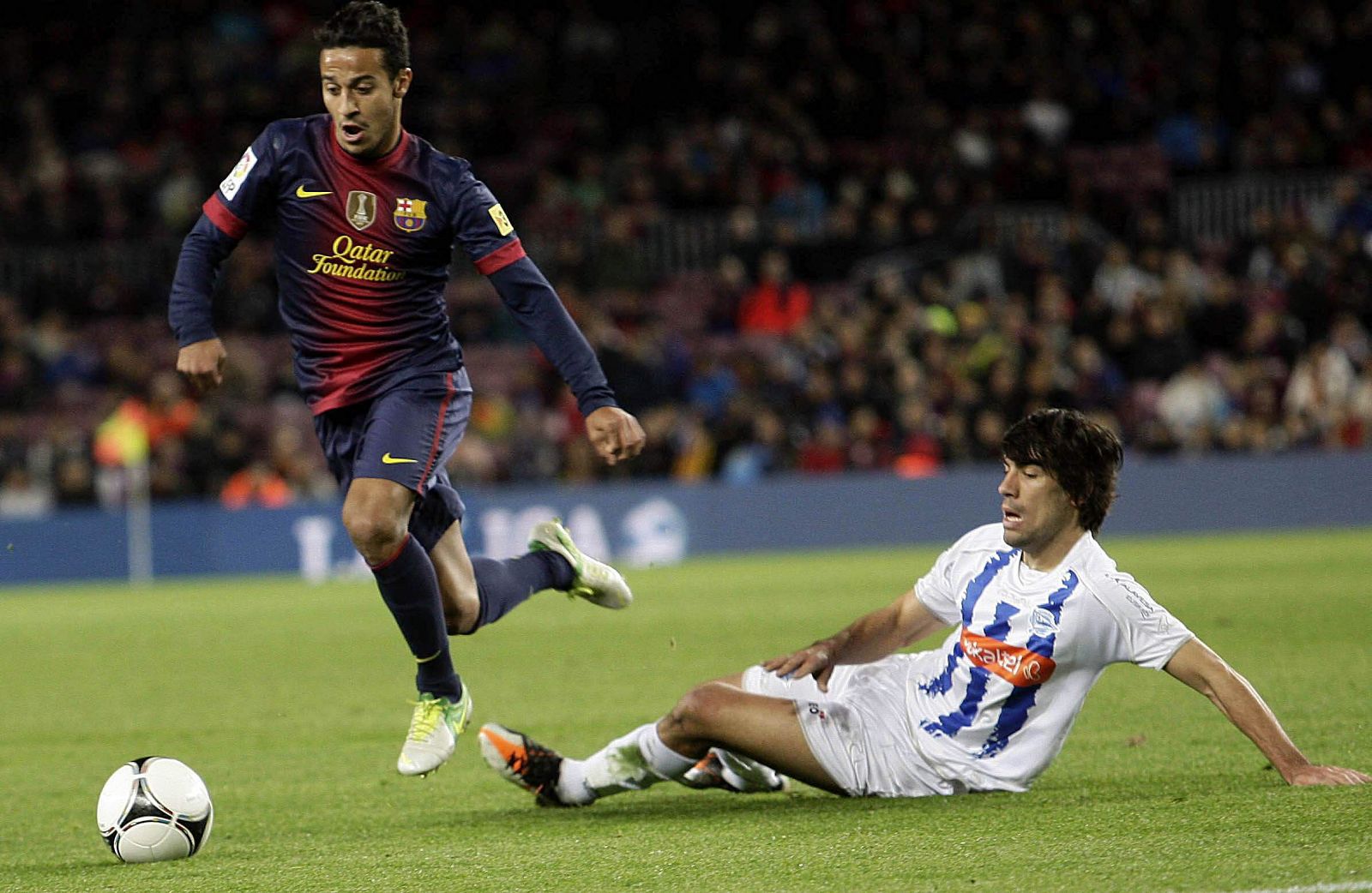 El centrocampista del FC Barcelona, Thiago Alcántara controla el balón ante el centrocampista del Alavés Manuel Alejandro García.