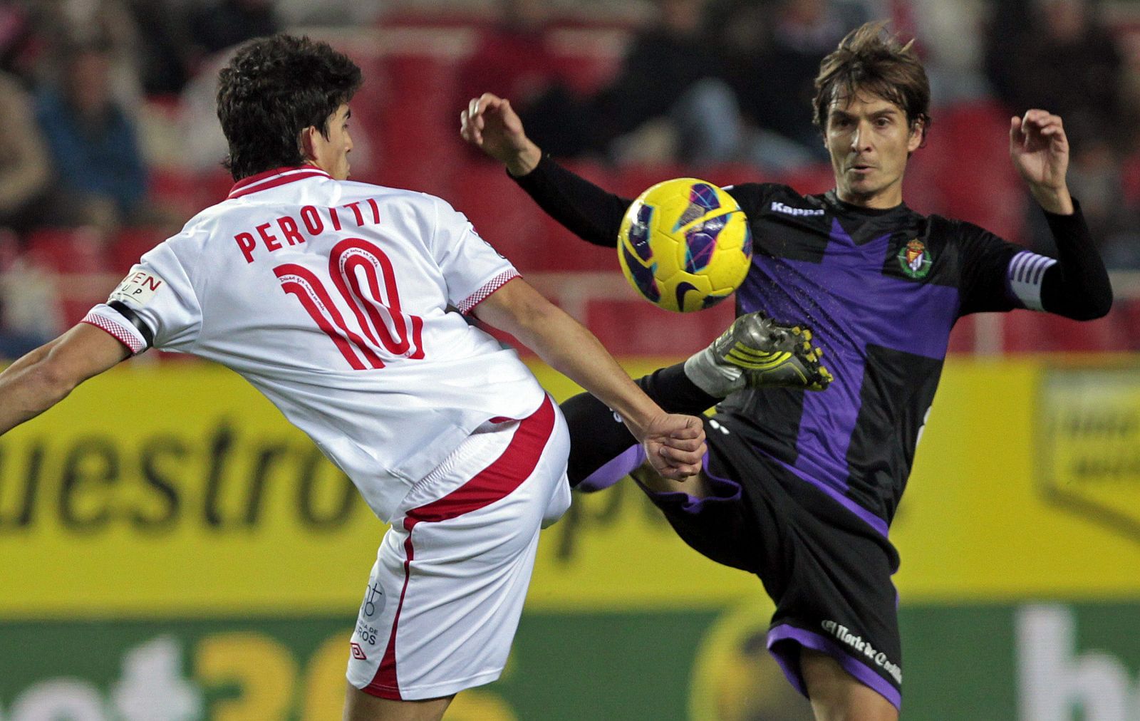 El centrocampista argentino del Sevilla CF, Diego Perotti (i), lucha el balón con Álvaro Rubio, centrocampista del Valladolid