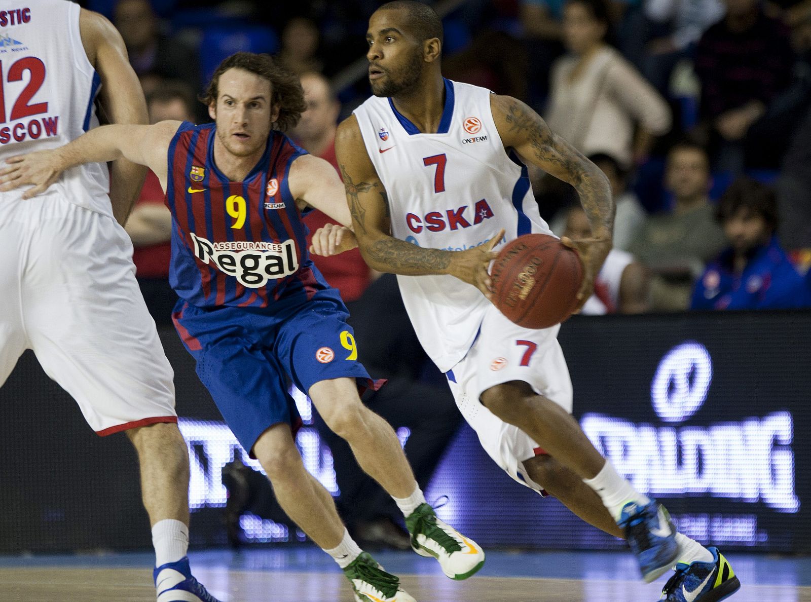 El base brasileño del Regal Barcelona Marcelinho Huertas defiende la posición del base estadounidense del CSKA Moscú Aaron Jackson (d)