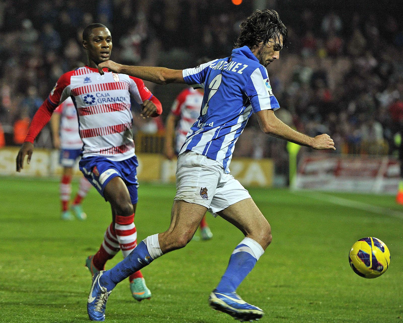 El delantero nigeriano del Granada Odion Ighalo (i) se acerca a disputar el balón al defensa del Real Sociedad Carlos Martínez (d)