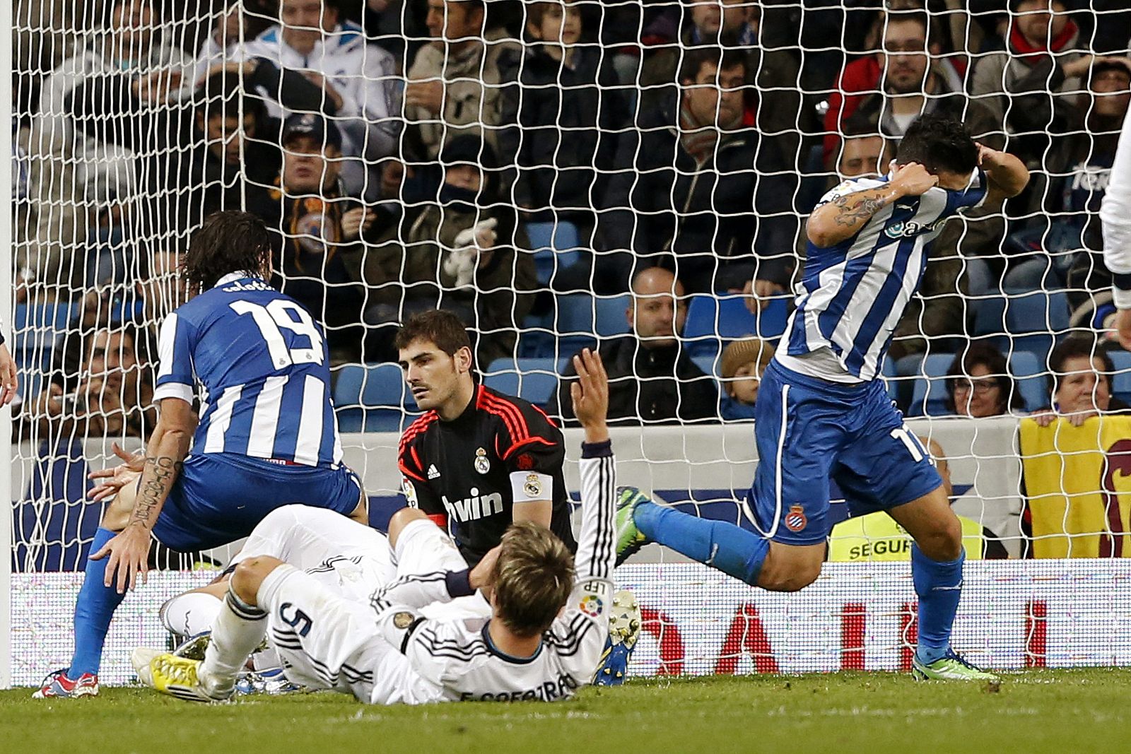 El portero del Real Madrid, Iker Casillas (c), en el suelo tras el gol marcado por el centrocampista uruguayo del RCD Espanyol Juan Ángel Albín