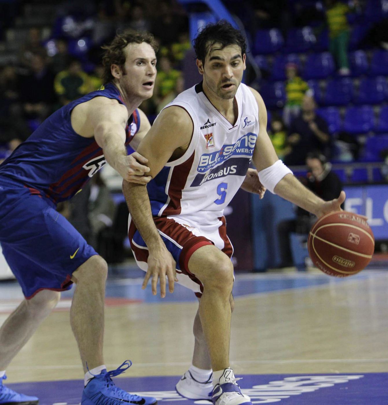 El jugador del FC Barcelona, Marcelinho Huertas, intenta bloquear al jugador del Blusens Monbus Obradoiro, Andrés Rodríguez.