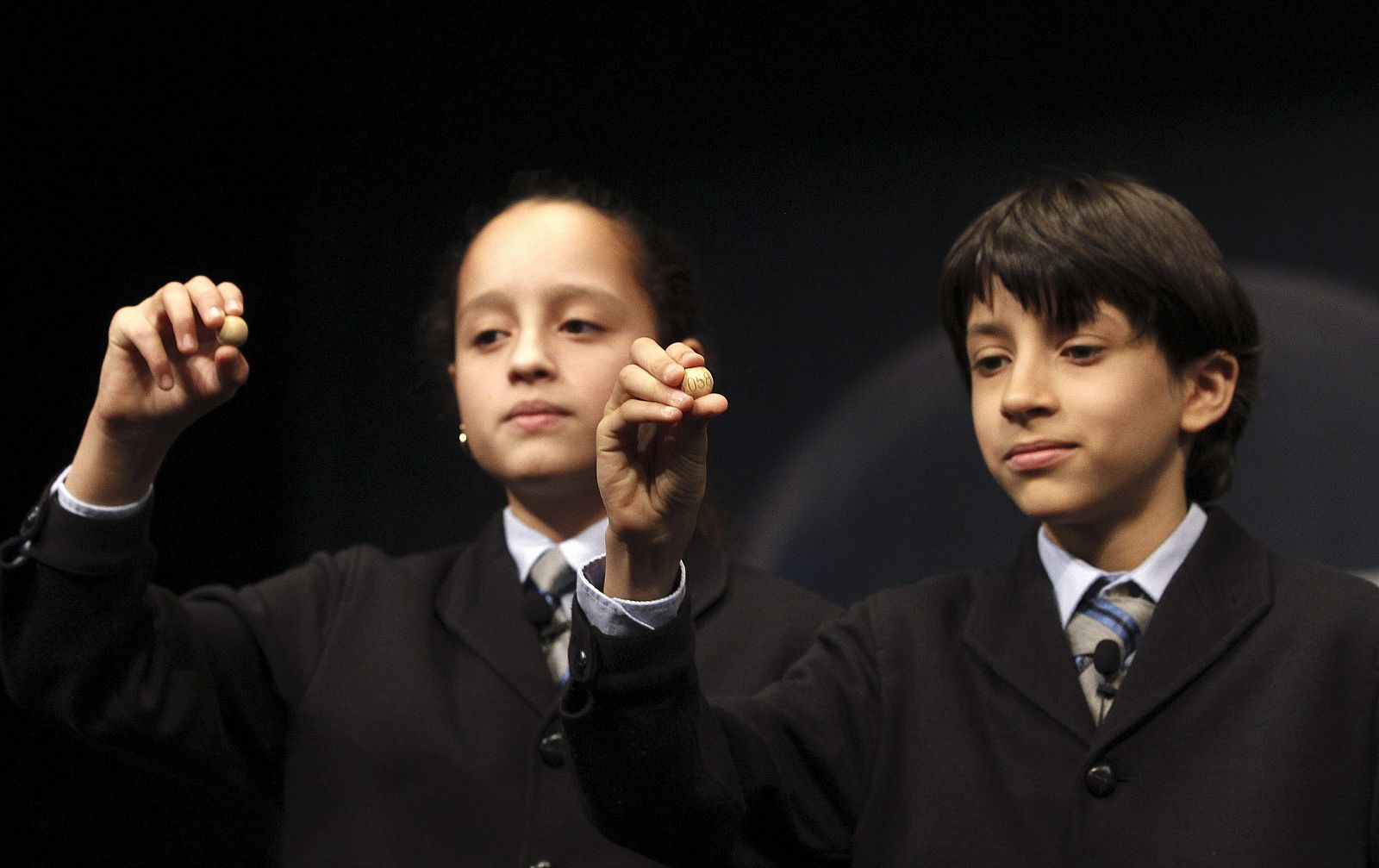 Los niños de San Ildefonso, Ismael Rastrelli y Sherley Fonseca, muestran el número 76.058 que ha sido agraciado con el premio Gordo, de 4 millones cada serie