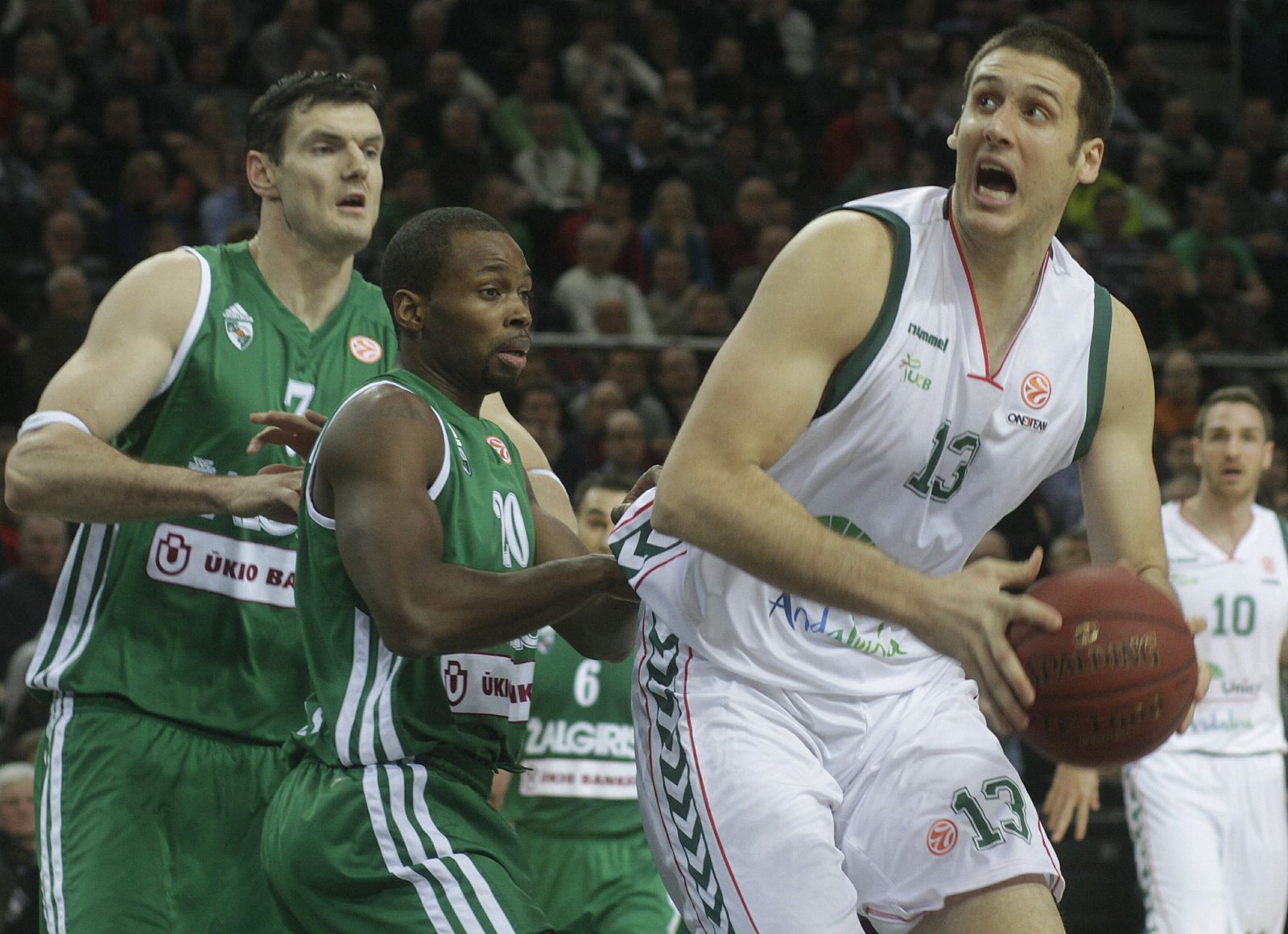 Darius Lavrinovic (i) y Oliver Lafayette (2i), del Zalgiris de Kaunas, en acción ante Kosta Perovic (d), del Unicaja.