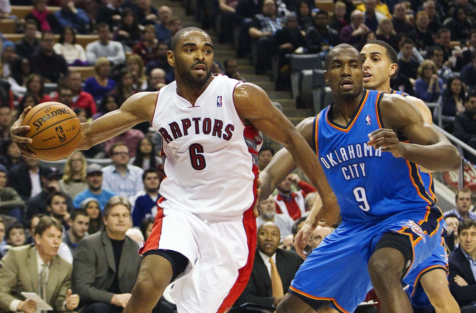 Raptors' Anderson drives to the basket past Thunder's Ibaka in the first half of their NBA basketball game in Toronto