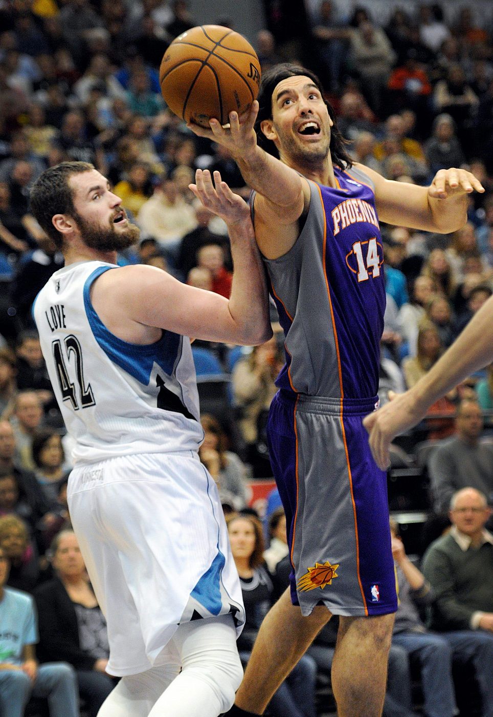 Kevin Love (i) de los Minnesota Timberwolves disputa el balón a Luis Scola de los Phoenix Suns