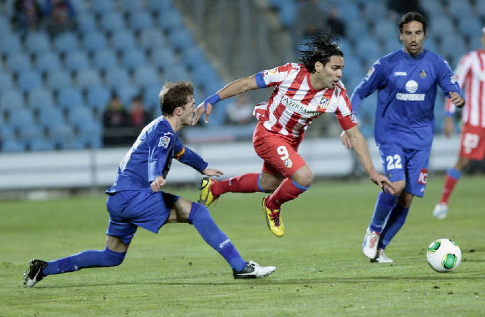 El delantero colombiano del Atlético de Madrid Radamel Falcao (c), avanza con el balón ante los jugadores del Getafe 