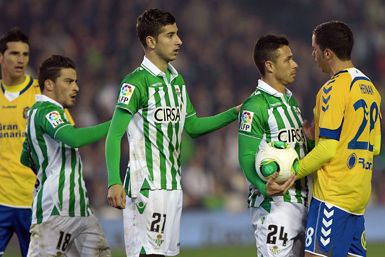 El centrocampista de la UD Las Palmas Hernán (d) se encara con Rubén Castro (2-d), del Real Betis