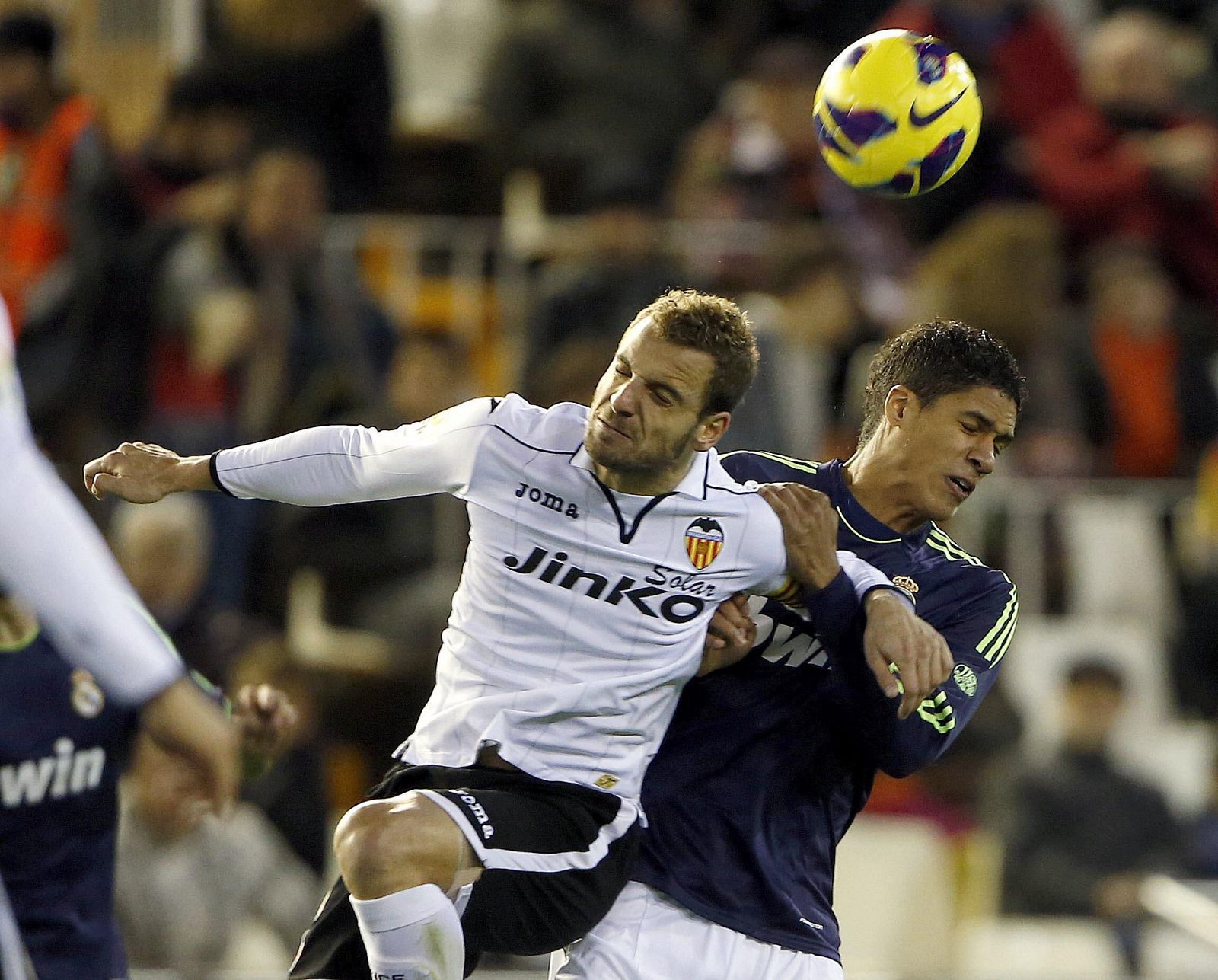 El delantero del Valencia CF, Roberto Soldado, salta por el balón con el francés Raphael Varane, del Real Madrid.