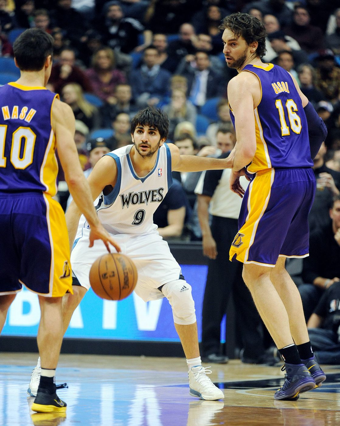 El jugador de los Timberwolves Ricky Rubio (c) ante Steve Nash (i) y Pau Gasol (d) de los Lakers.