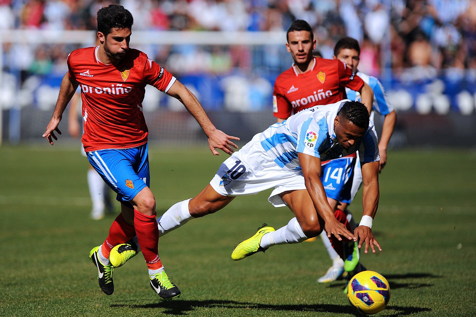 Julio Baptista cae ante el defensa del Zaragoza Álvaro González. El jugador del Málaga regresó al fútbol 15 meses después de sufrir una grave lesión.