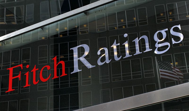 A flag is reflected on the window of the Fitch Ratings headquarters in New York