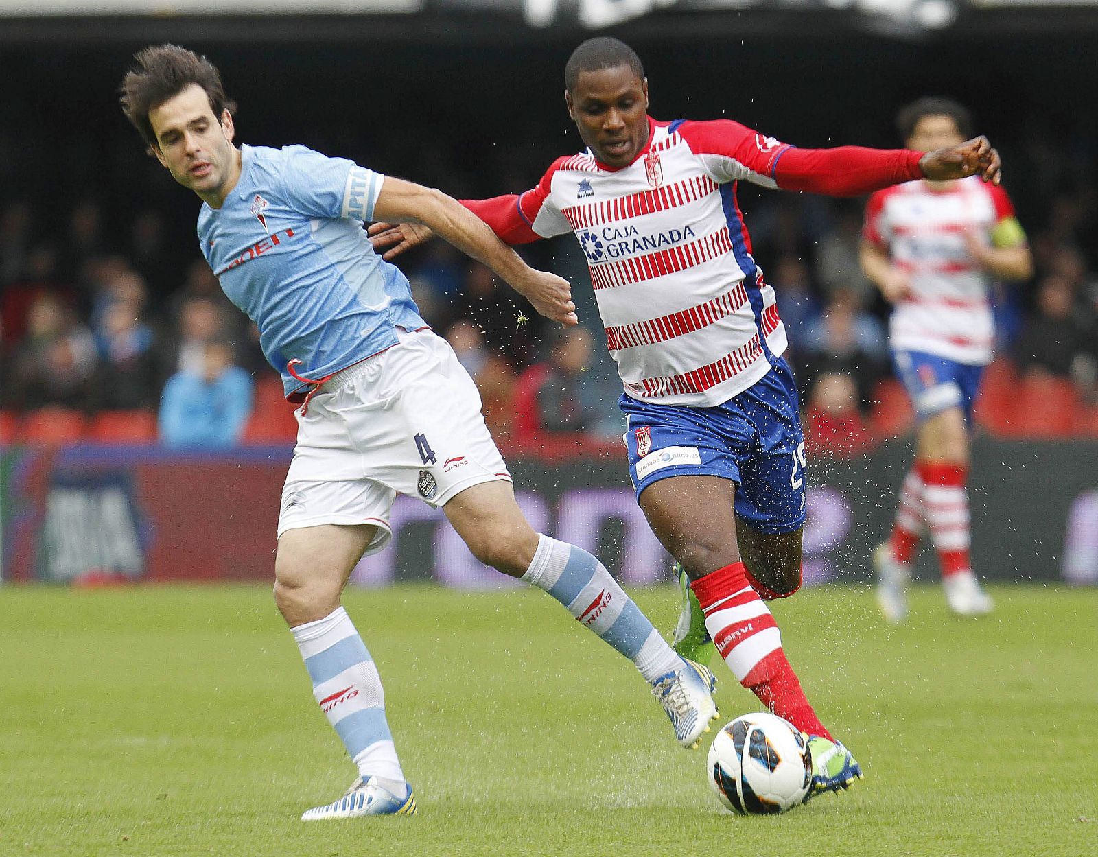 El centrocampista del Celta de Vigo Borja Oubiña lucha un balón con el delantero nigeriano del Granada Odion Ighalo.
