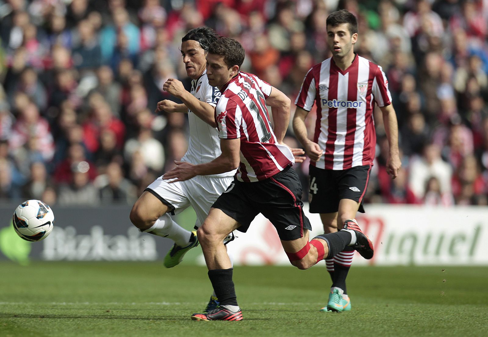 El delantero del Athletic Bilbao, Óscar de Marcos (c), y el centrocampista del Valencia, Dani Parejo (i).