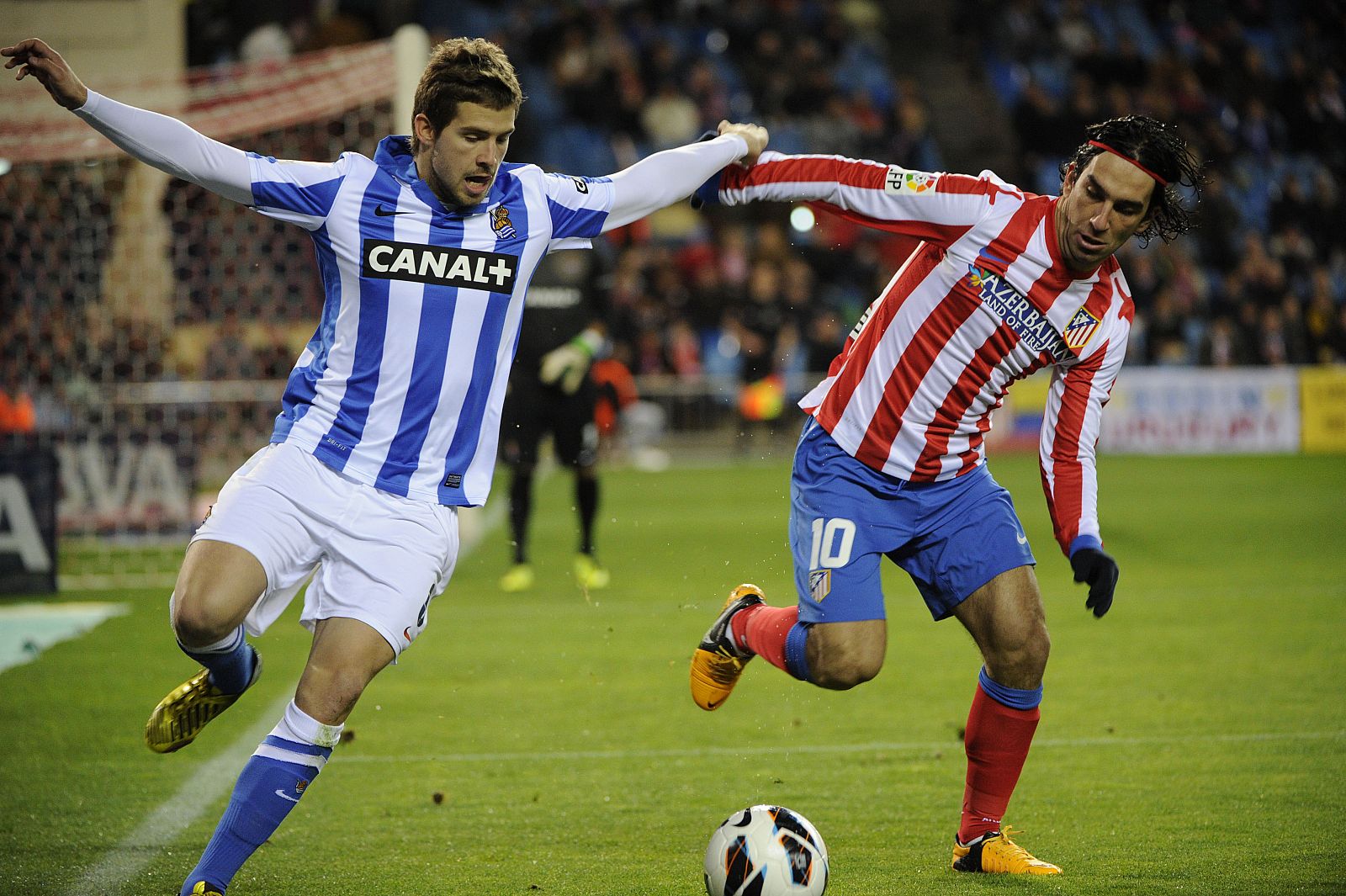 Turan e Iñigo Martínez pelean por un balón.