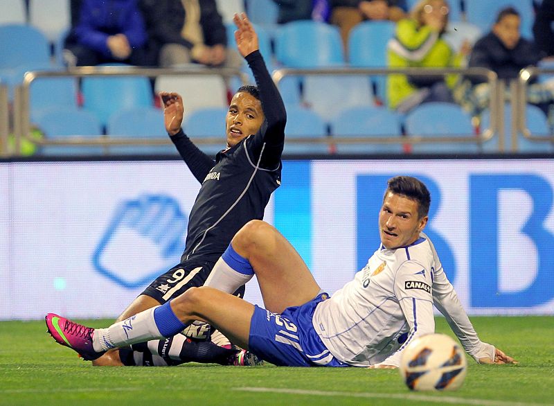 Adam Pinter (d) y Youssef El Arabi luchan por el balón durante el partido.