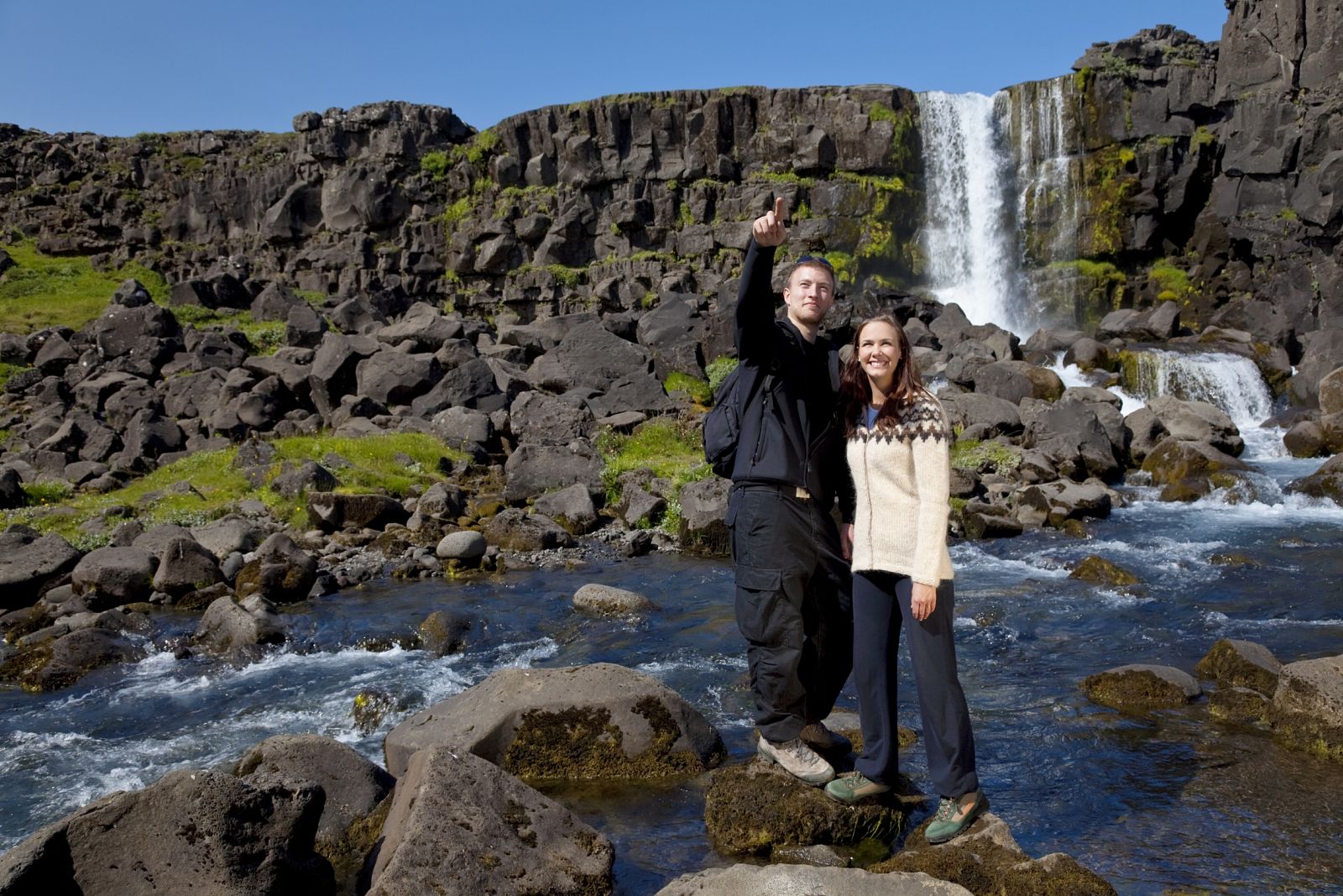 Una pareja junto a una cascada en Islandia